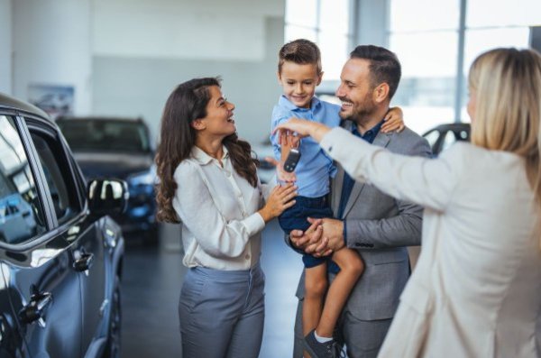 Young family collecting a new car